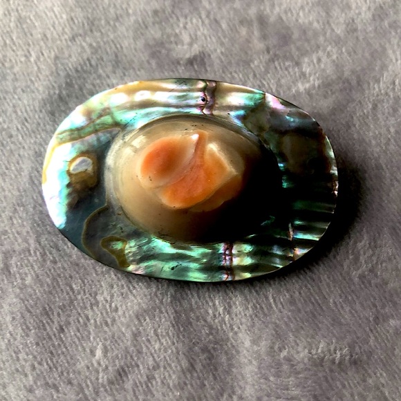 Vintage abalone shell pin shaped like a hat.